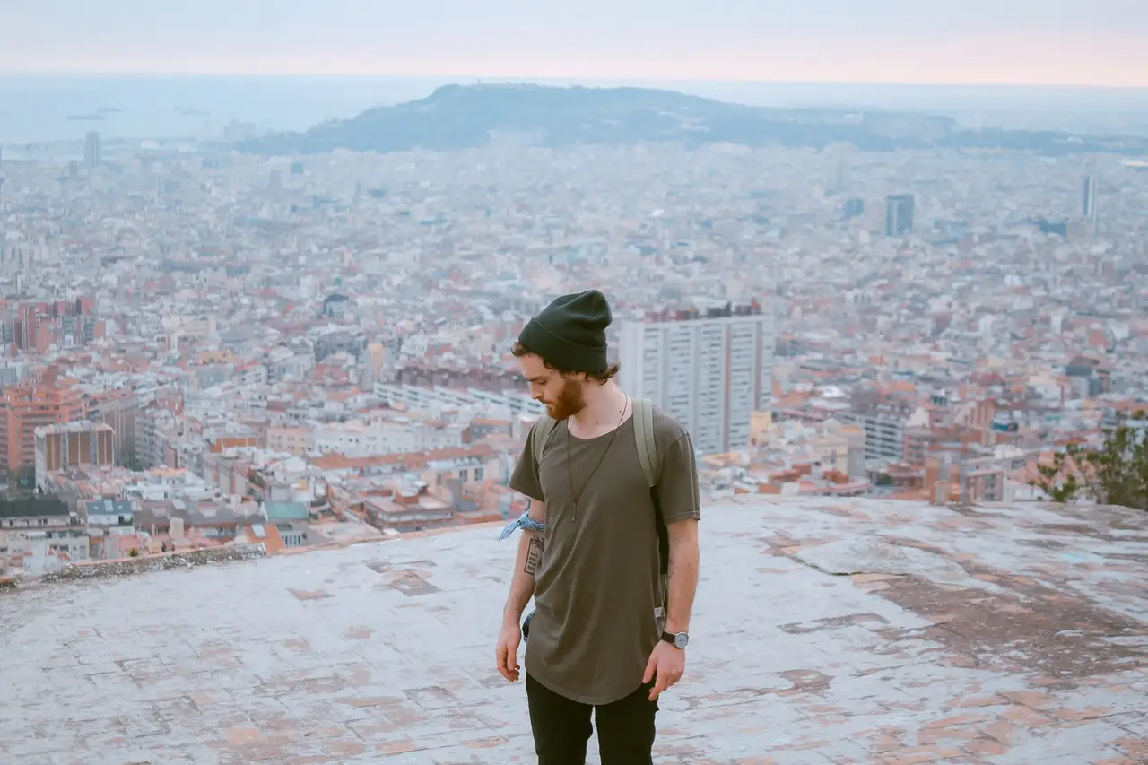 A lone traveller standing at a viewpoint above the rooftops of Barcelona