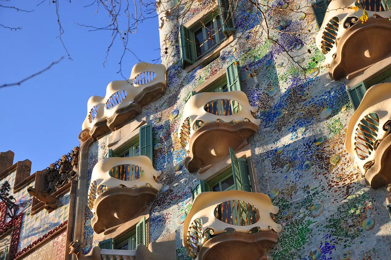 Mask-shaped balconies on the blue mosaic front of Casa Batlló, seen from below