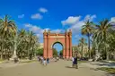 The red-brick Arc de Triomf at the end of a wide palm-lined promenade in Barcelona