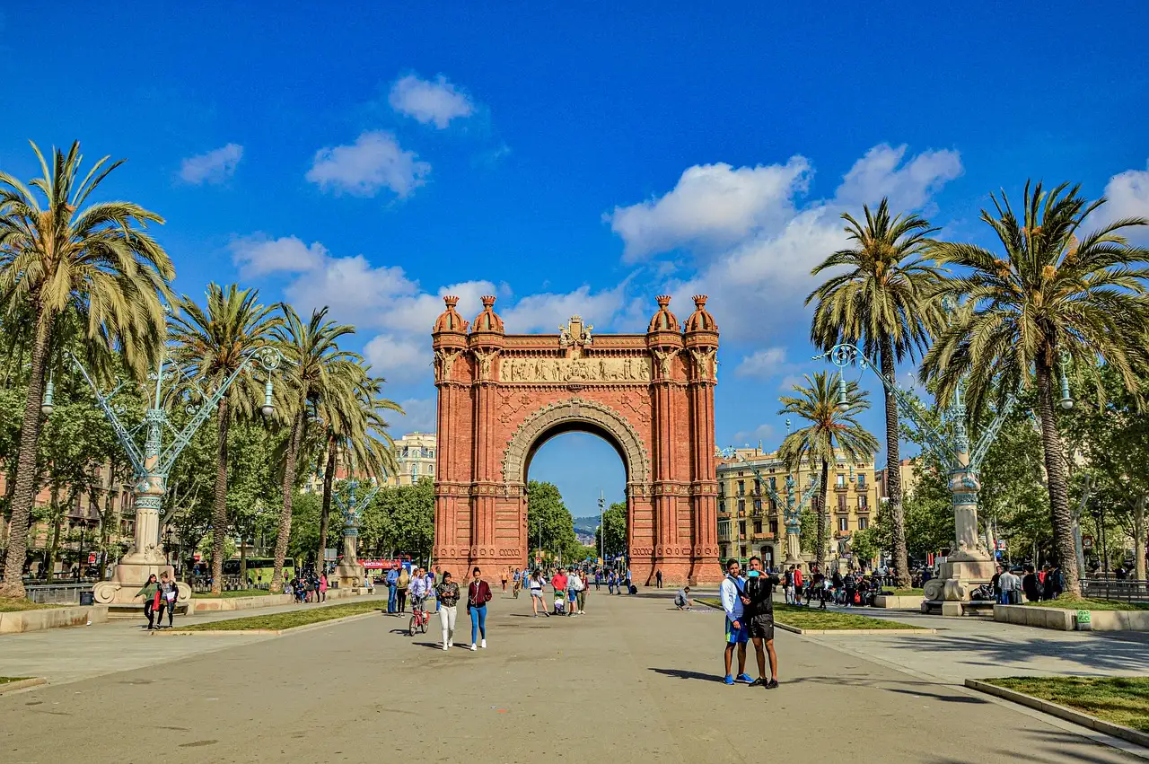 The red-brick Arc de Triomf at the end of a wide palm-lined promenade in Barcelona