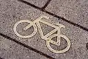 A white bicycle symbol painted on a paved bike lane