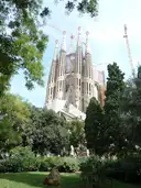The towers of the Sagrada Família rising above park trees