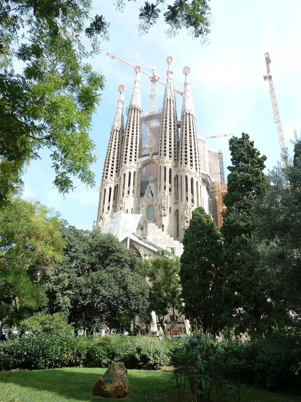 The towers of the Sagrada Família rising above park trees