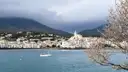 The white houses of Cadaqués around a calm bay, with hills behind