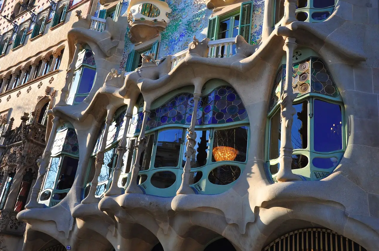The curved stone window frames and colored glass on the main floor of Casa Batlló