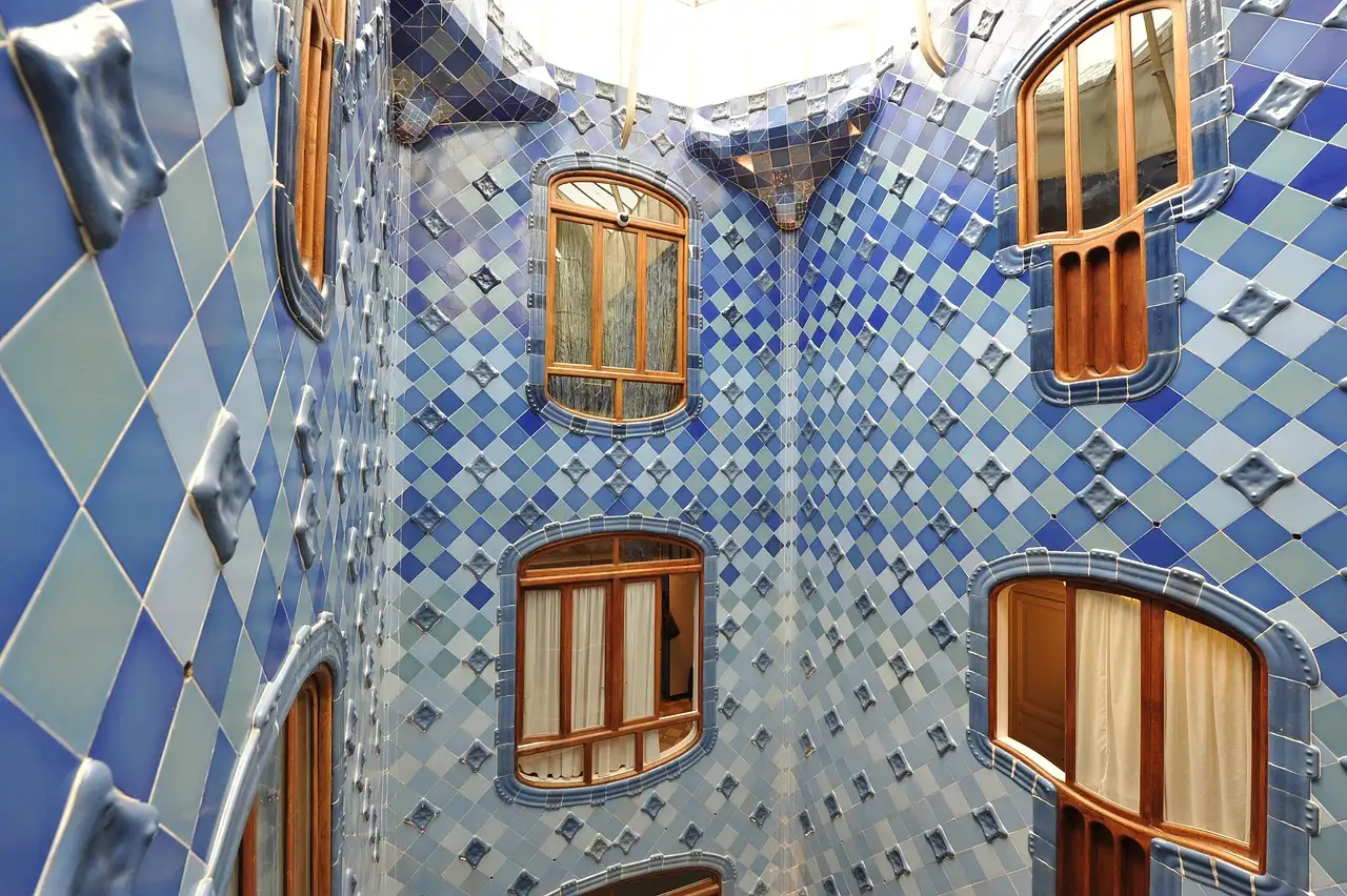The blue-tiled light well inside Casa Batlló, with curved wooden windows