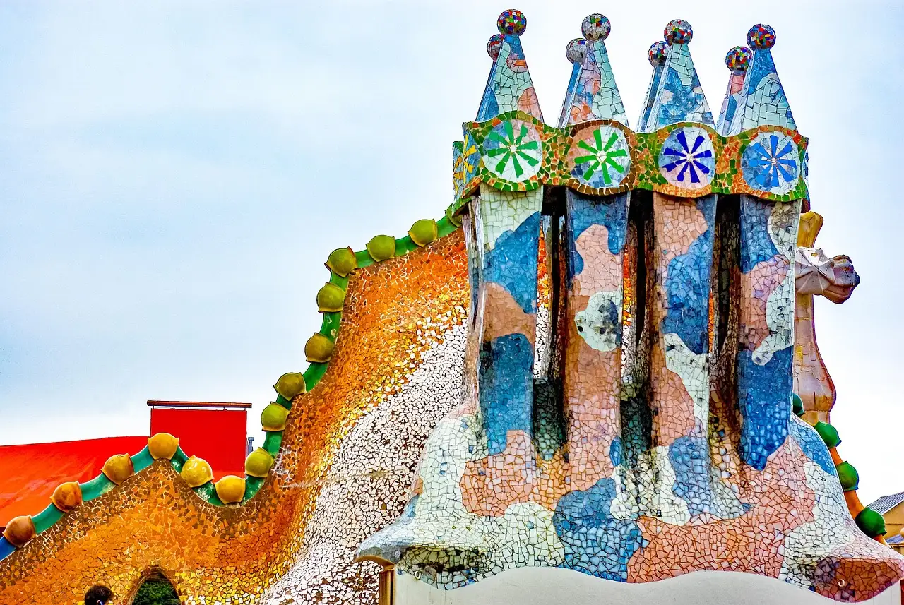 Colorful mosaic chimneys and the curved, scaled roof of Casa Batlló