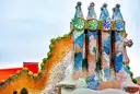 Colorful mosaic chimneys and the curved, scaled roof of Casa Batlló