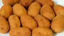 Golden fried croquettes piled on a plate