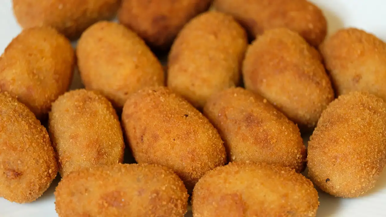 Golden fried croquettes piled on a plate