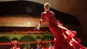 Flamenco dancer in a red ruffled dress performing on stage