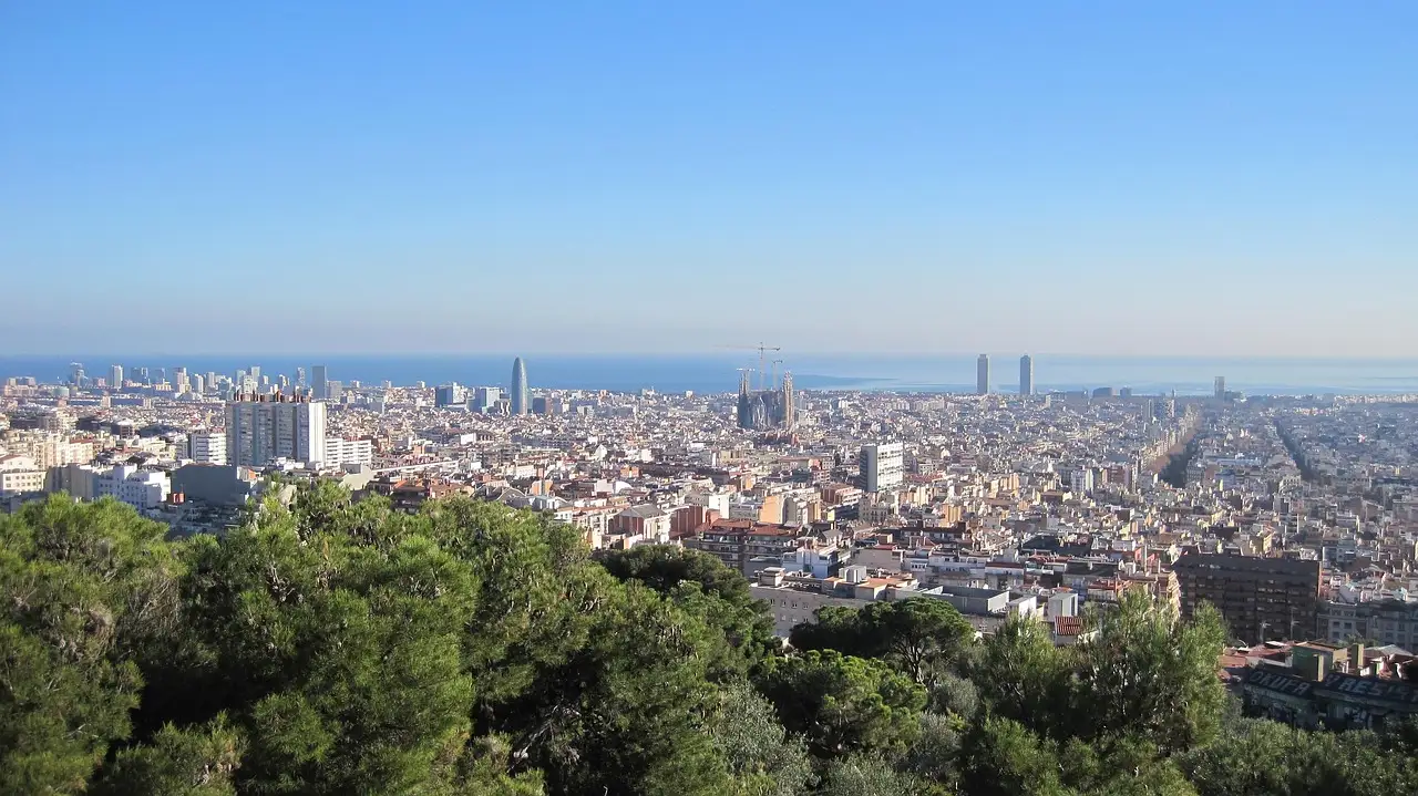 A wide view over Barcelona and the Mediterranean from the greenery of a hillside park