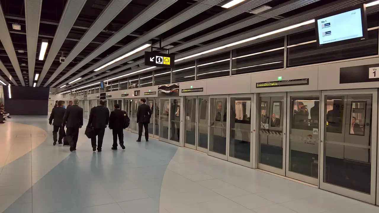 A modern Barcelona metro platform with glass safety doors along the track
