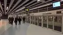 A modern Barcelona metro platform with glass safety doors along the track