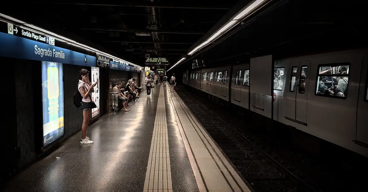 A metro train waiting at the Sagrada Família station platform in Barcelona