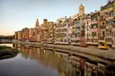 Painted houses and the cathedral of Girona reflected in the Onyar river at sunset