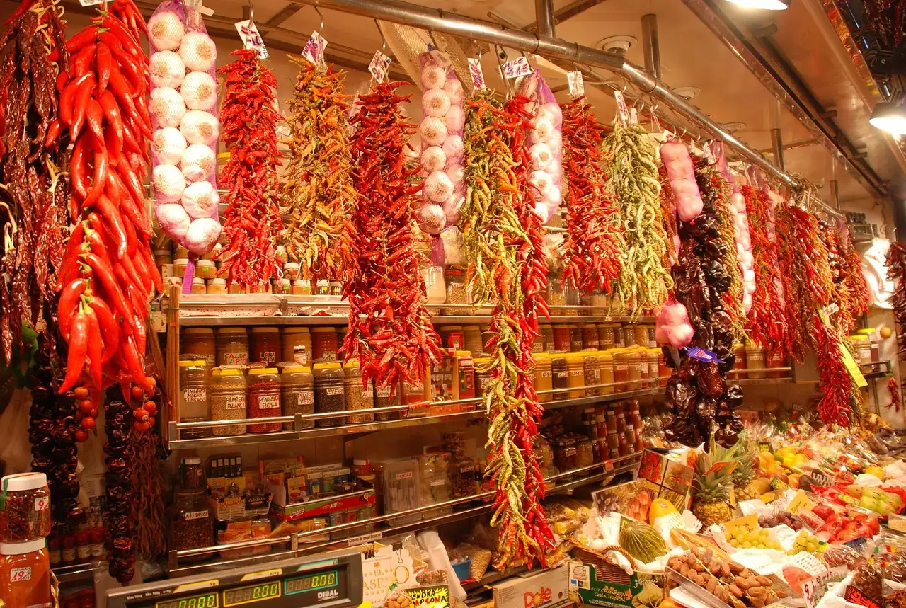 Strings of red and yellow peppers hanging over a stall at La Boqueria
