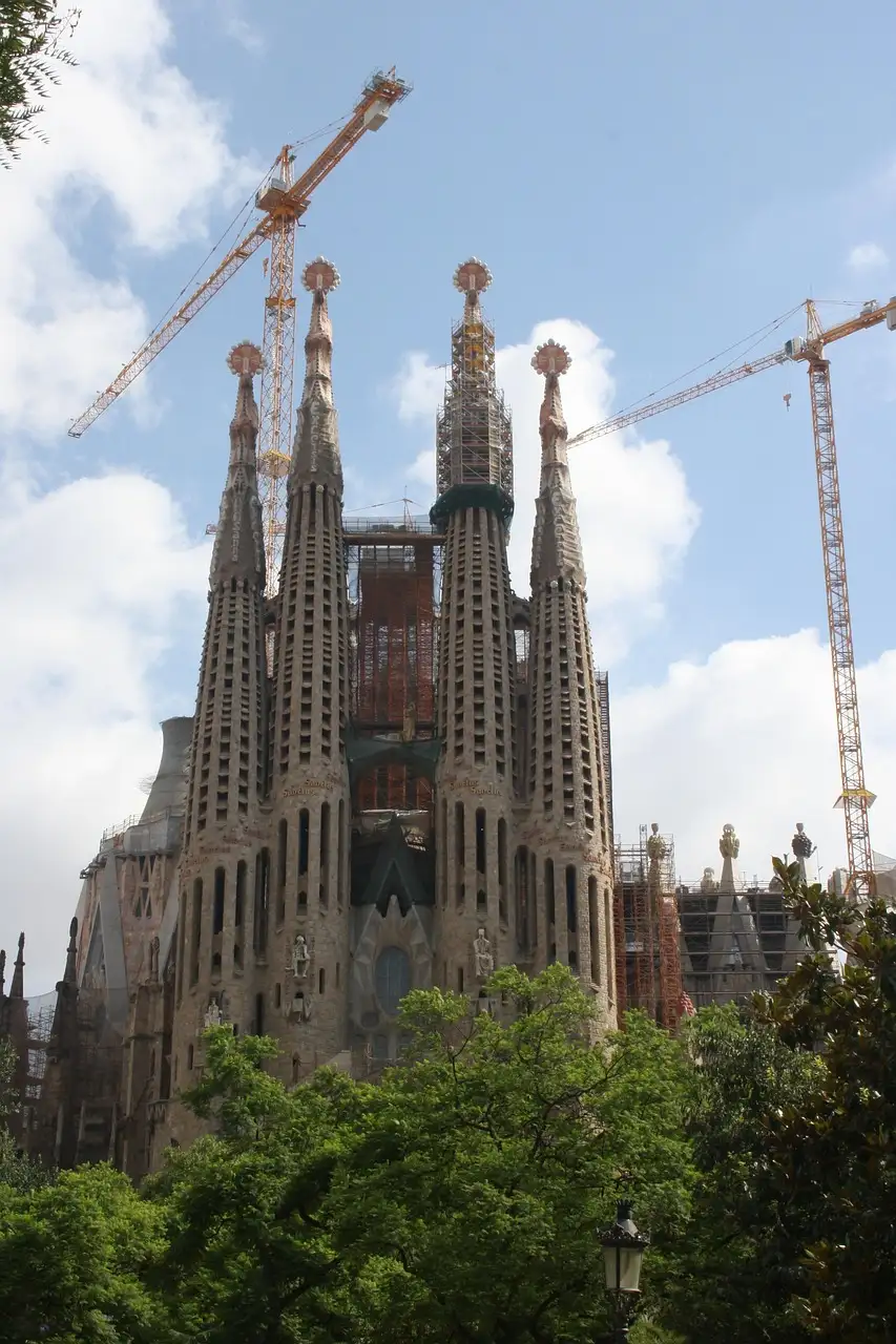 The towers of the Sagrada Família with building cranes above them