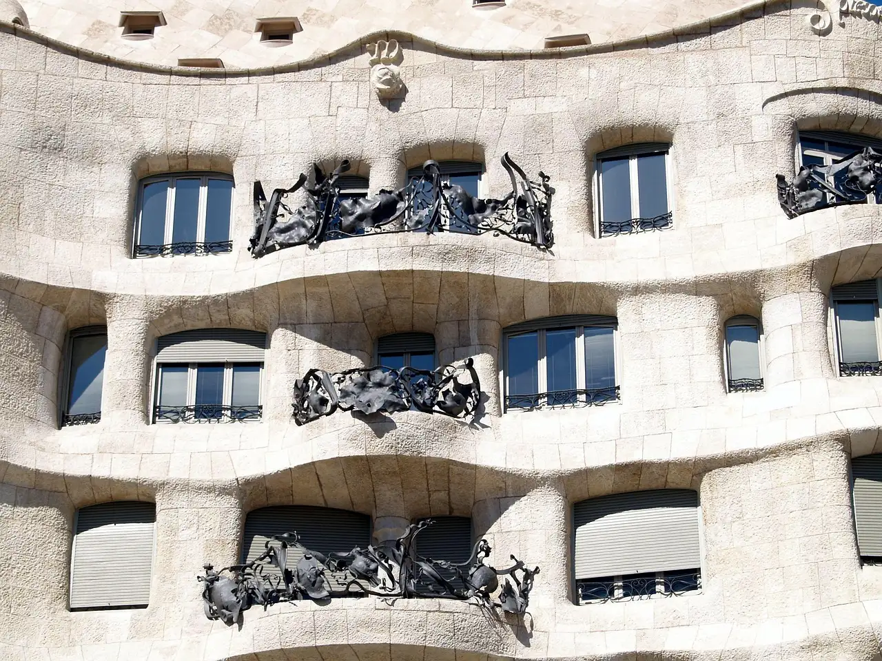 The pale stone facade of La Pedrera with dark wrought-iron balconies