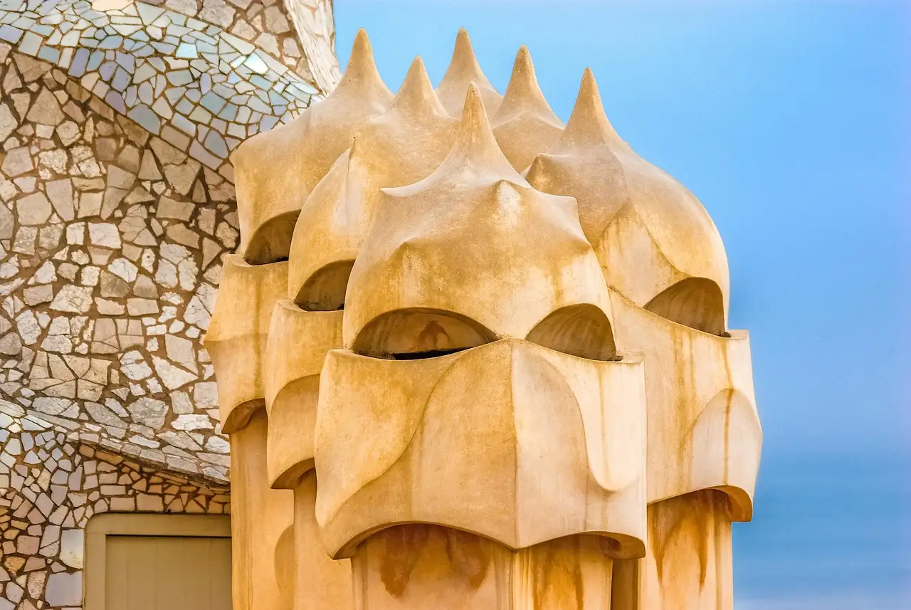 Sand-colored chimneys shaped like helmeted heads on the roof of La Pedrera