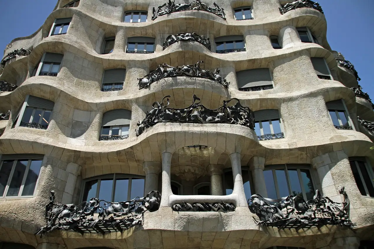 The wavy stone facade of La Pedrera with its twisted iron balconies, seen from below
