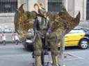 Living-statue street performer on La Rambla with a yellow and black taxi behind