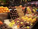 Fruit stall at La Boqueria with oranges, avocados and fruit cups