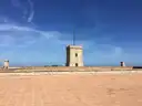 Watchtower on the stone terrace of Montjuic Castle under a blue sky