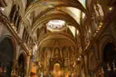 The long nave of the Montserrat basilica with its painted ceiling and gold altar
