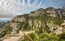 A stone viewpoint and path on the green cliffs of Montserrat under a cloudy sky