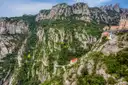 The monastery of Montserrat tucked under grey cliffs above a green valley