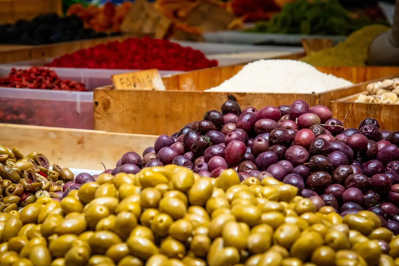 Green and purple olives piled on a market stall