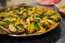 Finished seafood paella with lemon wedges and peas