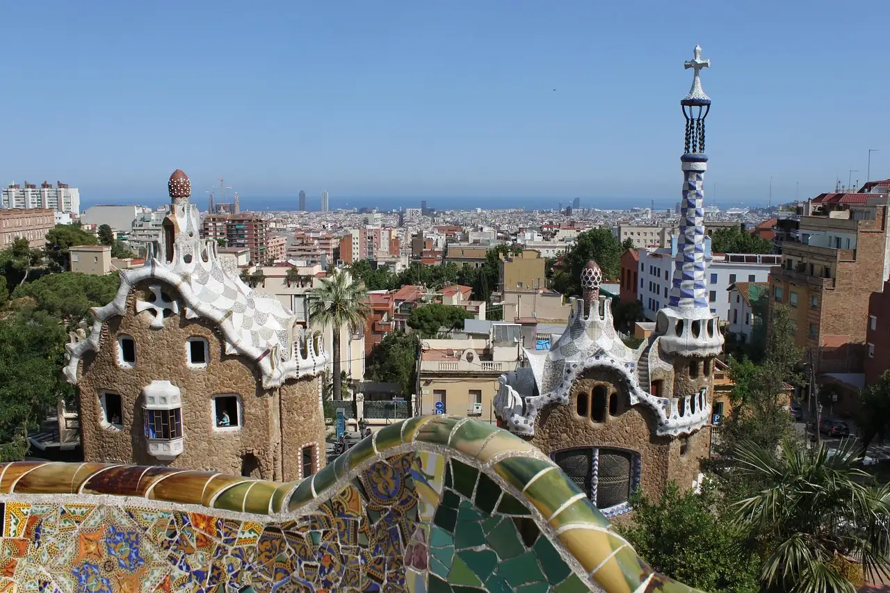The two gatehouses of Park Güell with their mosaic roofs, above the rooftops of Barcelona