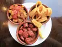 Tapas plate with potatoes in spicy sauce, fried squid rings and chorizo