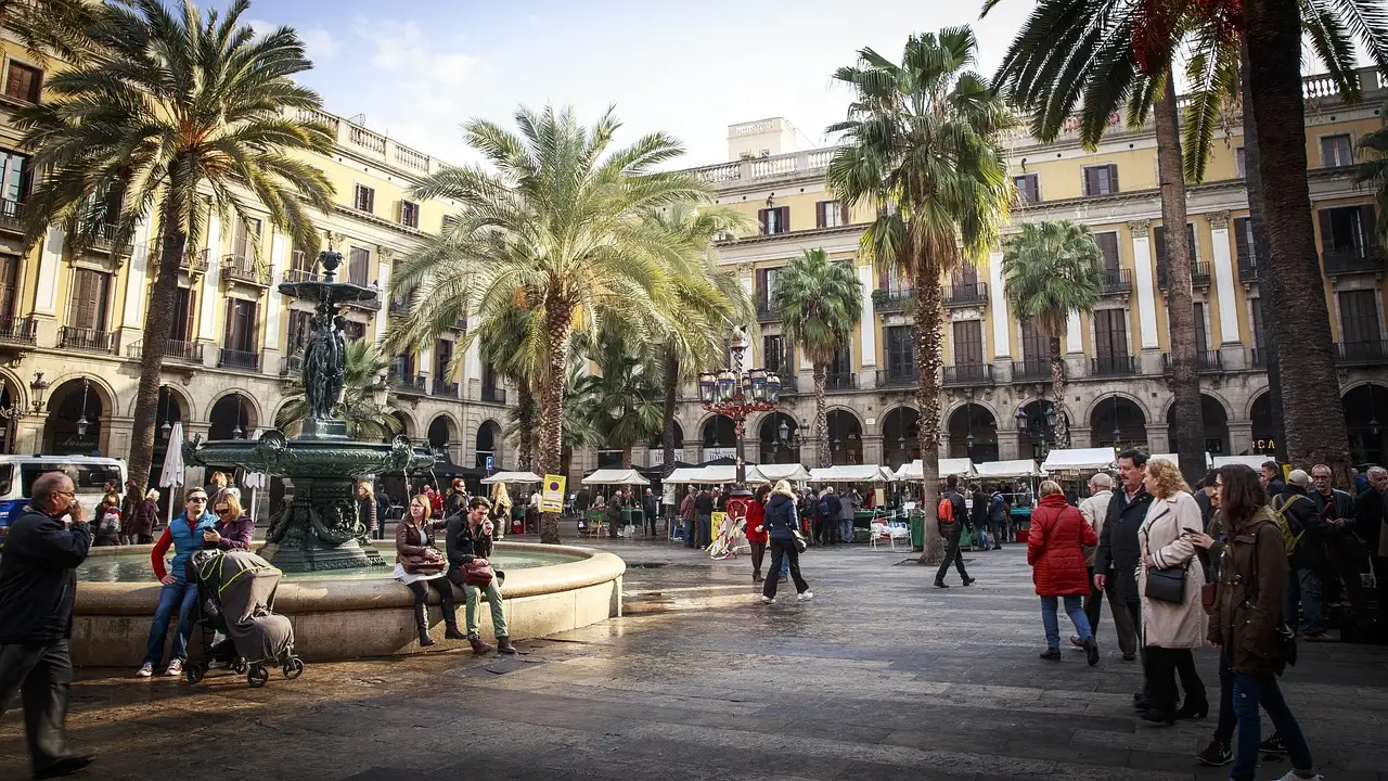 Palm trees and fountain in Placa Reial, Barcelona, with arcaded buildings