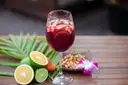 Glass of sangria with fruit next to cut limes