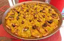Large pan of saffron paella with mussels and prawns