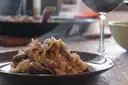 Steaming plate of rice with clams and a glass of red wine