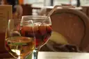 Glass of sangria with fruit next to a glass of white wine on a cafe table