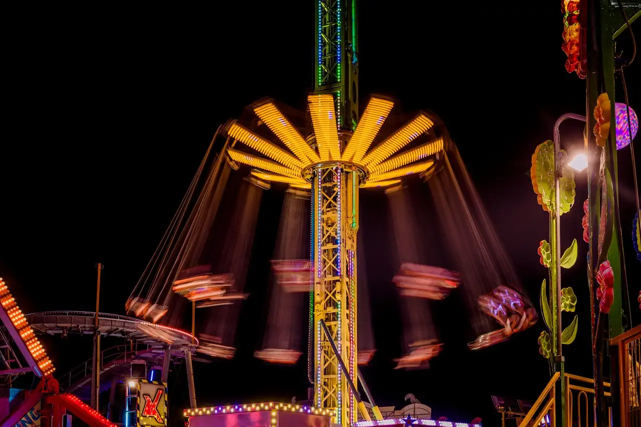 Theme park rides lit up in bright colors at night