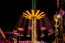 Theme park rides lit up in bright colors at night