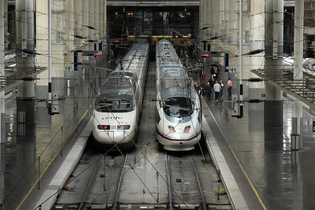 Two high-speed trains side by side at a station platform in Spain