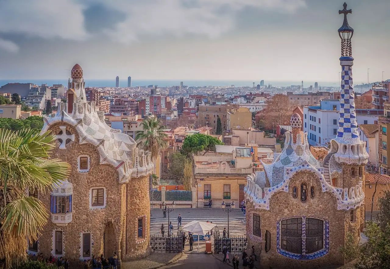 The mosaic-roofed gatehouses at the entrance of Park Güell, with the city below