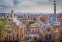 The mosaic-roofed gatehouses at the entrance of Park Güell, with the city below
